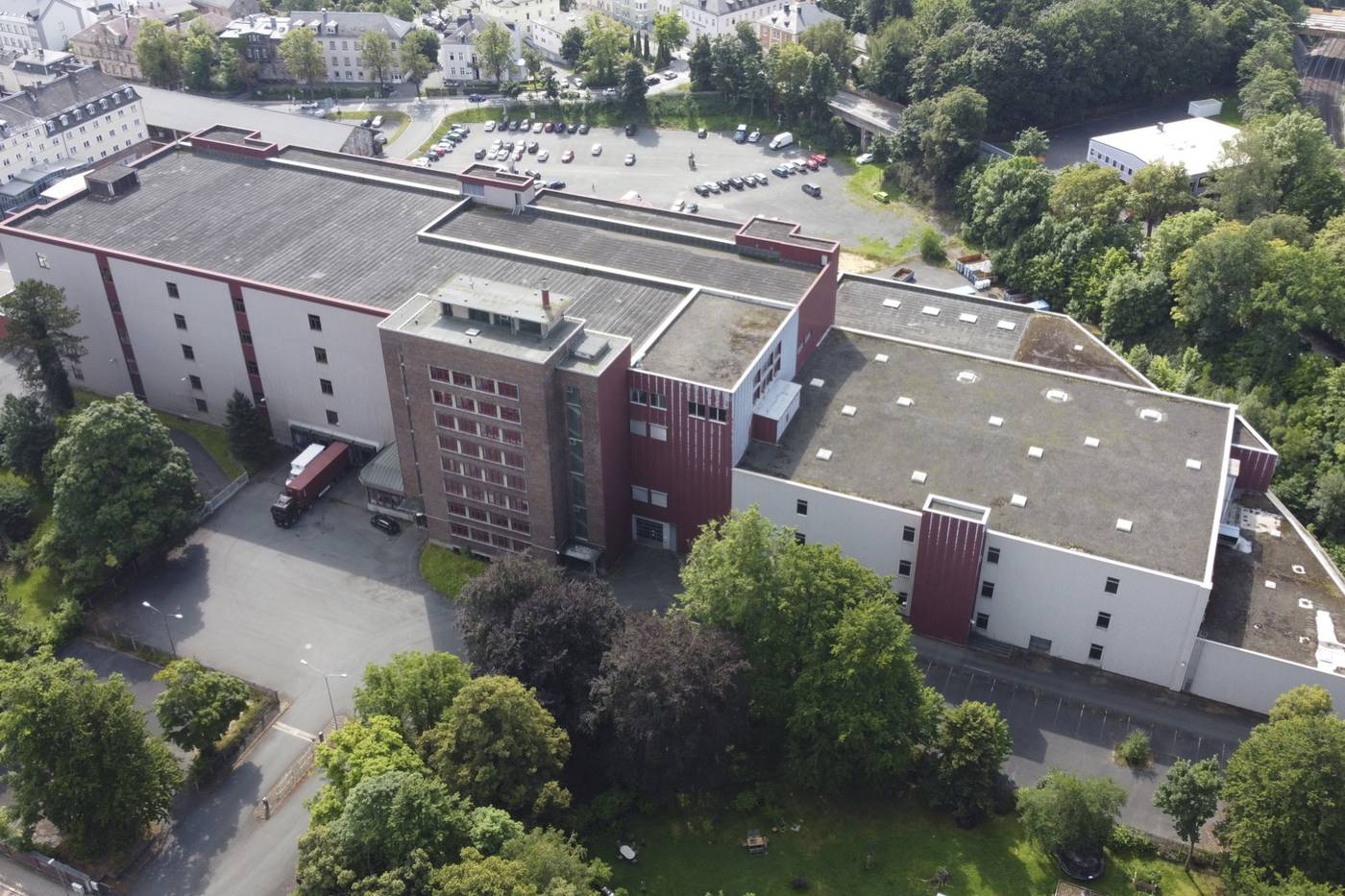 Luftbild des Spinnerei-Areals in Hof mit Hauptgebäude, Turm und Hallen inmitten der Stadt
