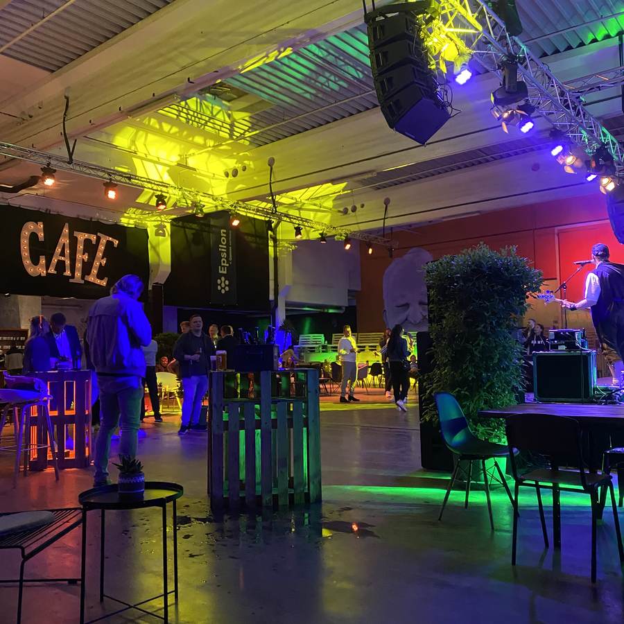Innenraum der südlichen Halle mit Bar, Café-Leuchtschrift und farbigem Licht