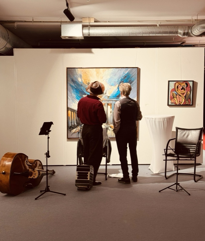 Besucher vor Gemälden in der Nicoleta Gallery im Living Berlin, Kontrabass im Vordergrund